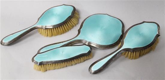 A 1920s silver and guilloche enamel four piece brush and mirror set.